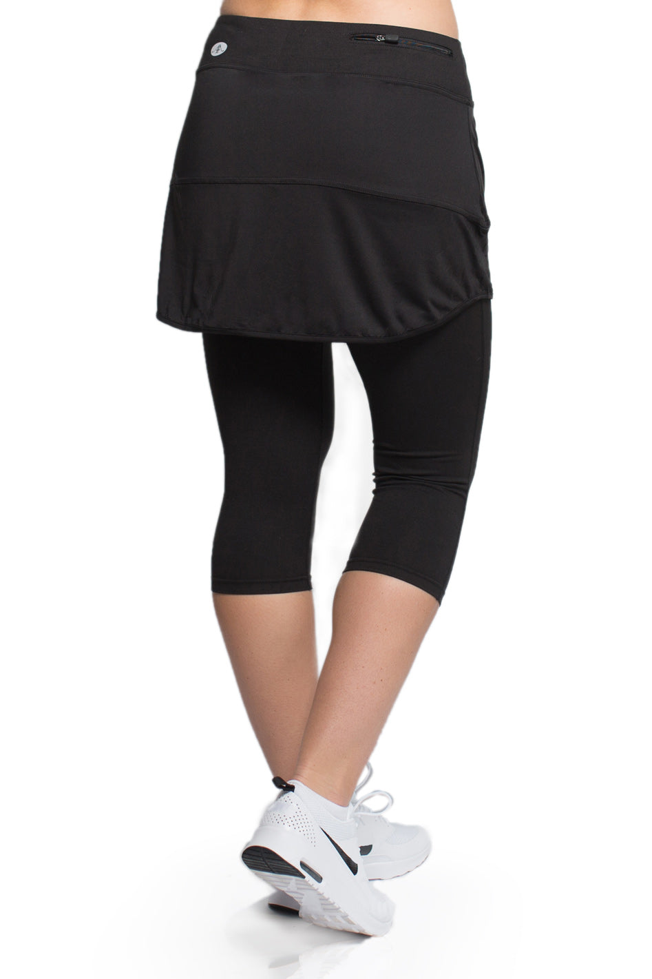 Woman showcasing the Endurance Skirted Capri Legging in black#color_black