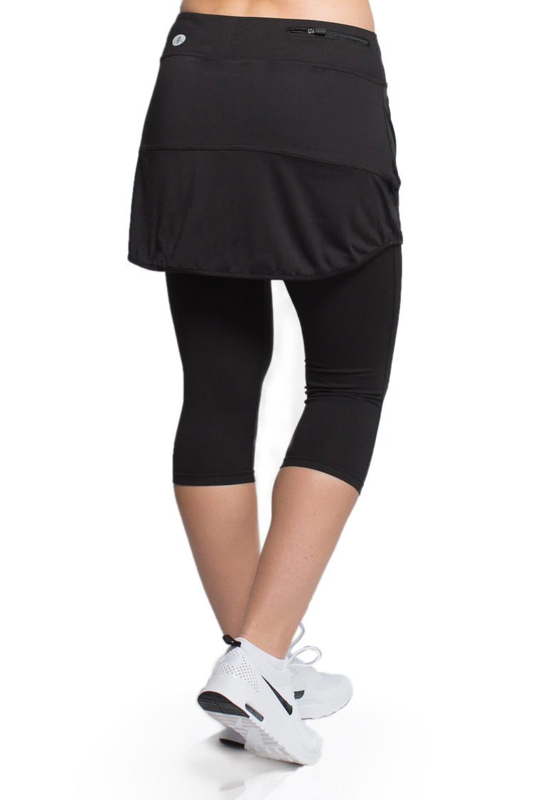 Woman showcasing the Endurance Skirted Capri Legging in black#color_black