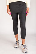 #color_charcoal-black-heather  A person wearing black skirted leggings and white sneakers, with a plain background.