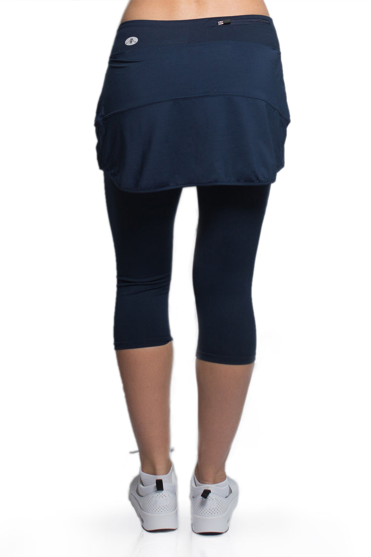 Rear view of a woman wearing the Alex + Abby Endurance Skirted Capri Legging in blue