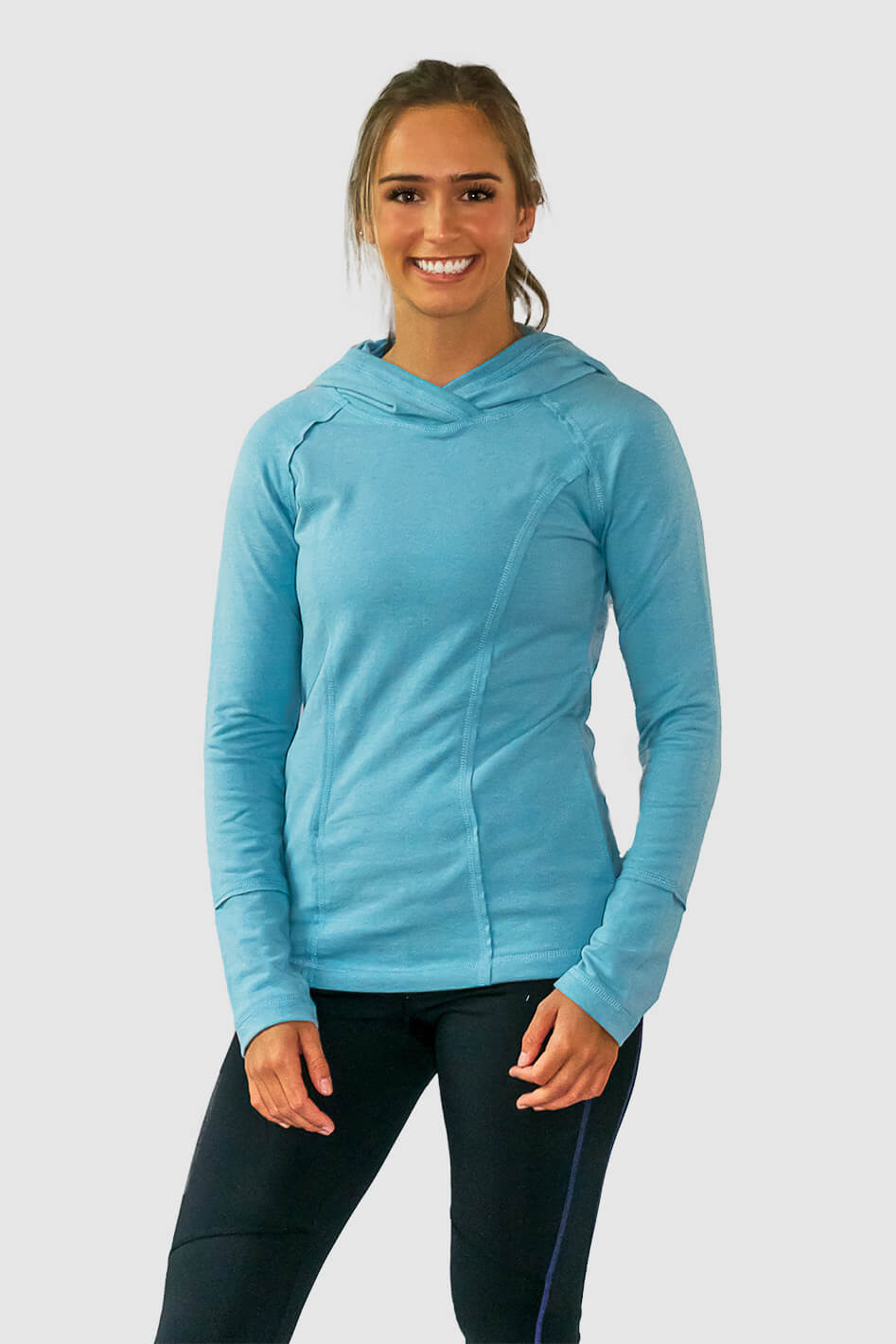 #color_tahitian-blue A woman wearing a blue lounge hoodie with a hood, long sleeves, and standing pose.